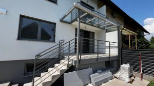 Balkonski nadstešek s stekleno streho podaljšek iz balkona z železno ograjo Balkonski nadstešek s stekleno streho podaljšek iz balkona z železno ograjo