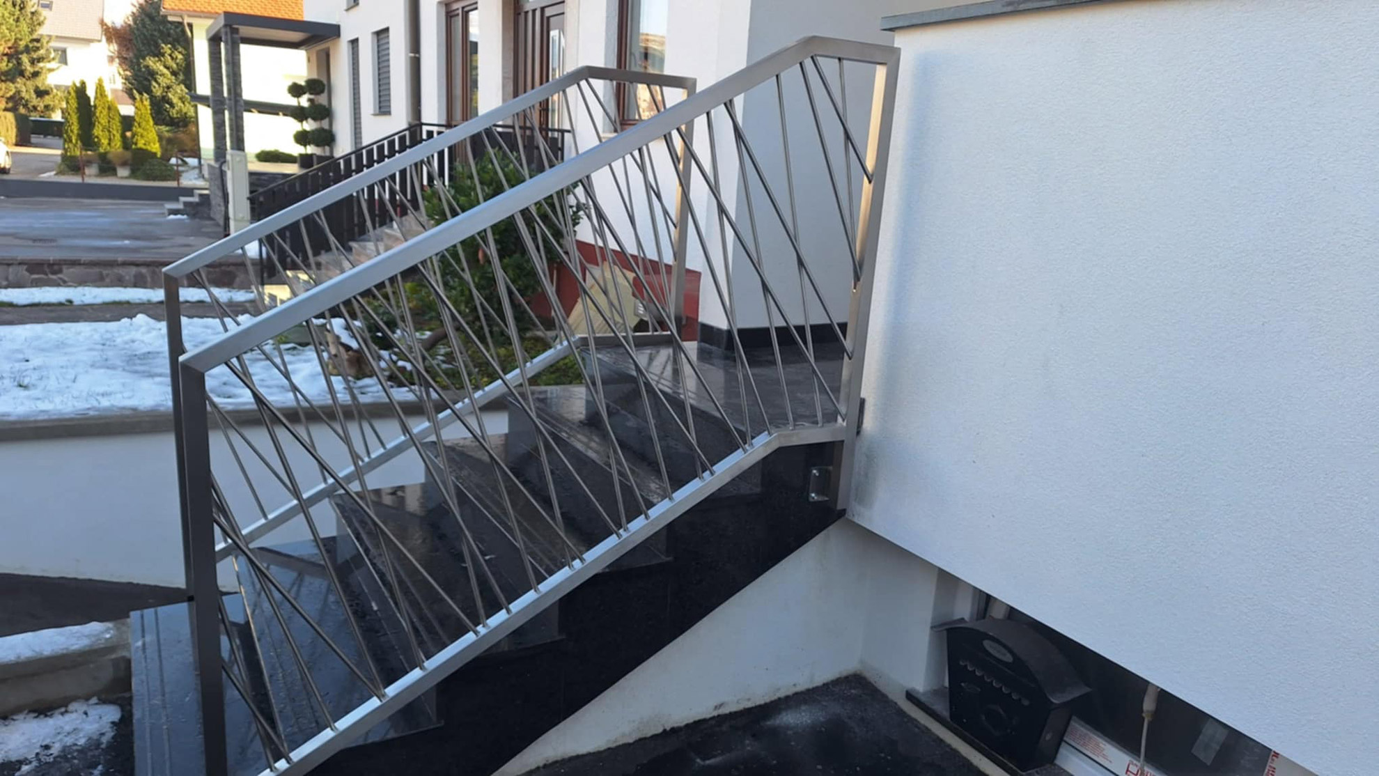 Moderna-Zunanja-stopniscna-inox-ograja Pletena inox ograja za stopnice pred vhodom.