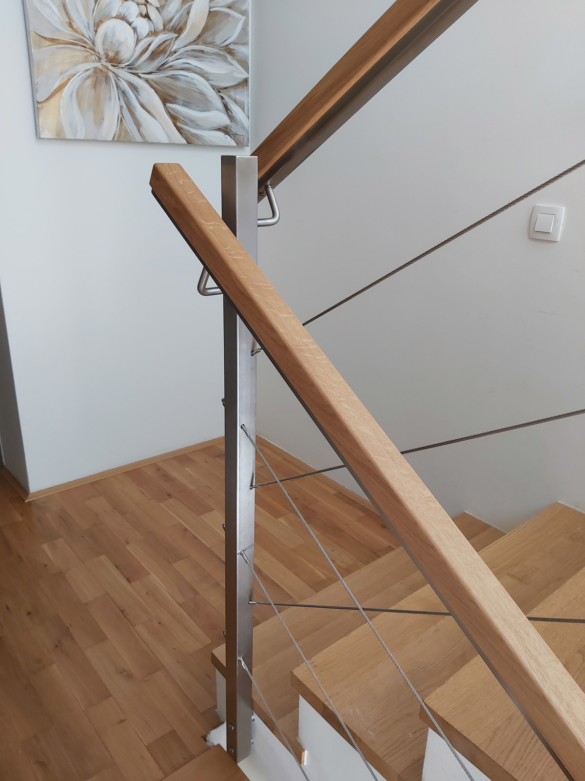 Notranja-stopniscna-inox-ograja-z-zicami-in-lesom-moderna Inox ograja z lesenim kockastim ročajem in pletenico vlečeno po dolžini v kombinacijo s kombinacijo stopnice oblečene v les